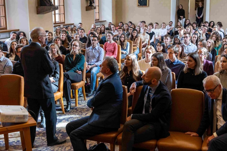 UK Forum/Hynek Glos: Profesoři Jan Konvalinka, Jan Trka a Marek Babjuk (sedící zleva v první řadě) naslouchají slovům děkana George Q. Daleyho (stojící řečník).