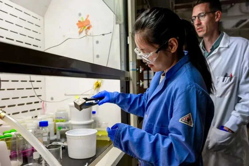 University of Notre Dame / Matt Cashore: Menglin (Mae) Jiang, a Ph.D. student in Doudrick’s lab soaks a piece of concrete in a solution to see how much PFAS it has absorbed.
